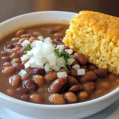 a white bowl filled with beans and cornbread