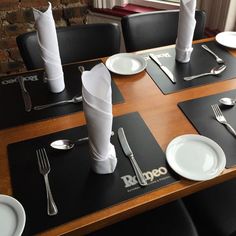 the table is set with silverware and napkins on it, along with other place settings