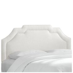 an upholstered headboard with white linen