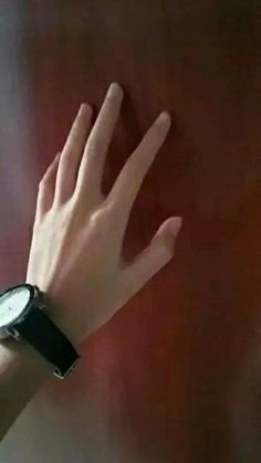 a person's hand with a wrist watch on their left and the other hand