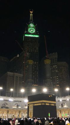 a large group of people standing in front of a building with a clock on it