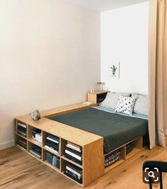 a bed sitting in the middle of a bedroom next to a wooden table and chair