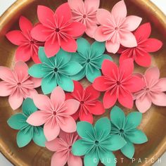 paper flowers in a wooden bowl on a table