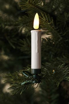 a lit candle hanging from a christmas tree