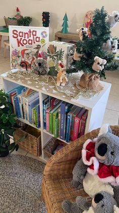 two stuffed animals sitting in front of a bookshelf with christmas decorations on it