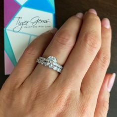 a close up of a person's hand with a ring on it and a business card in the background