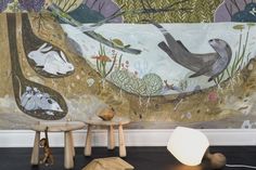 an animal themed wallpaper in a children's room with two stools and a lamp