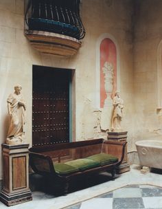 a room with statues and a bench in the center, along with a bathtub