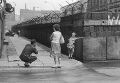 an old black and white photo of children playing on the side walk with their parents