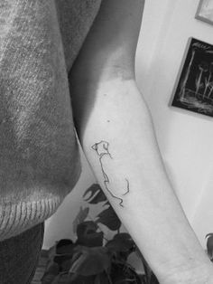 a black and white photo of a person's arm with a cat tattoo on it