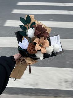 a person holding a bouquet of flowers on the street