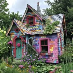 a colorful house with lots of flowers around it