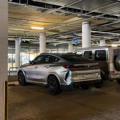 two cars parked in a parking garage with no one around them or on the ground