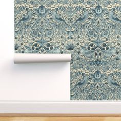 a wall with a blue and white pattern on it next to a roll of paper