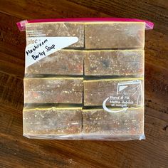 several pieces of soap sitting on top of a wooden table next to a package of brownies