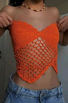 a woman wearing an orange crochet crop top