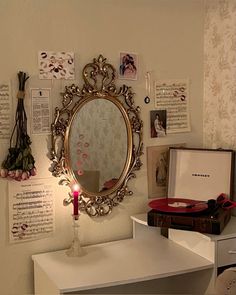 a mirror on the wall above a table with a candle and other items around it