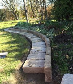 a stone path in the middle of a grassy area