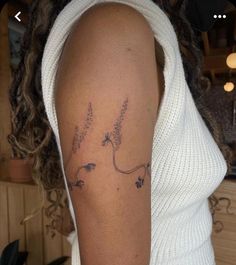 a woman's arm with flowers on it and the word love written in cursive writing