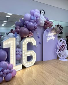 a large balloon arch with the number sixteen surrounded by balloons