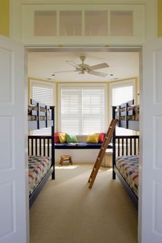 there are two bunk beds in this room and one has a ladder on the wall