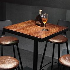 three stools and a table with a wine glass on it