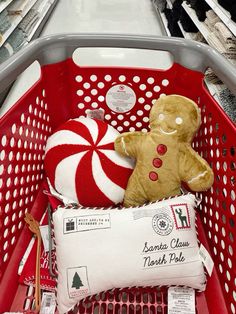 a red shopping basket filled with stuffed animals and candy canes on top of it