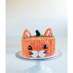 there is a cake that looks like a cat on the plate with ears and eyes