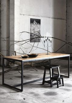 a wooden table with two black chairs next to it and some candles on the table