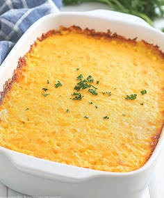 a casserole dish with cheese and parsley in it on a white plate