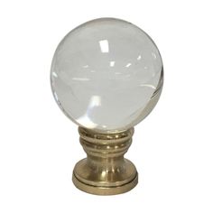 a clear glass ball on a brass base