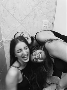 three young women are laughing in the bathroom