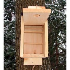 a wooden bird house hanging on a tree