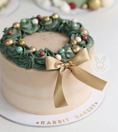 there is a cake decorated with green and gold decorations on the top, as well as a bow