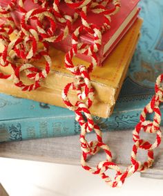 a red and white rope is on top of a stack of books, next to a pair of scissors