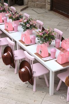 a long table with pink chairs and bags on it