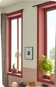 a living room filled with furniture and two large windows covered in pink curtains next to a window sill