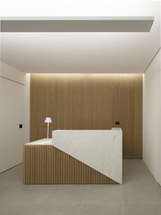 a white counter sitting in the middle of a room next to a light brown wall