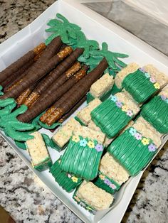 a box filled with lots of green and brown desserts on top of a counter