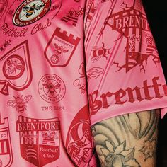 a man with tattoos on his arm wearing a pink shirt that has been printed onto it