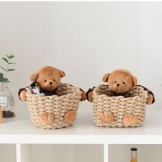 two teddy bears sitting in baskets on top of a shelf