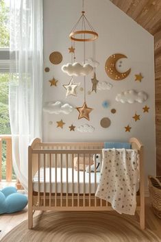 a baby's room decorated in white and gold with stars, moon and clouds on the wall