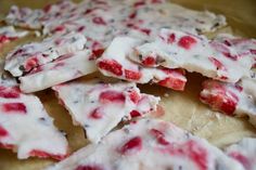 some kind of food that is on top of a wooden table with red and white toppings