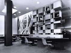 an office with large bookshelves and chairs in the center, along with a painting on the wall