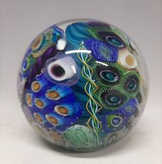 a glass ball with an artistic design painted on it's side and eyes in the center