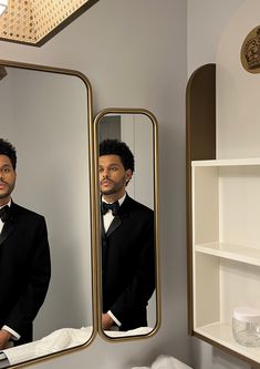 a man in a tuxedo looking at himself in the mirror