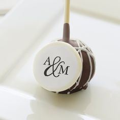 a white and brown cake ball with a monogram on it