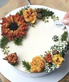 a cake decorated with flowers and leaves on a table