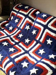 an american flag crocheted afghan is displayed on a bed with white and red stars