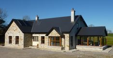 a stone house with black roof and windows